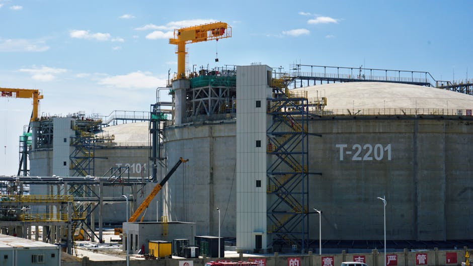 Large storage tanks and cranes at an industrial facility supporting carbon capture infrastructure