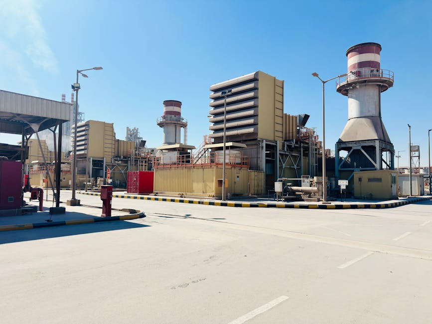 Natural gas power plant with turbines and stacks under clear sky